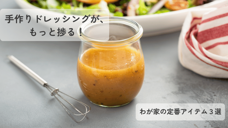 小さな泡立て器と手作りドレッシングが入ったガラス瓶。わが家の定番キッチンツールを紹介するイメージ。