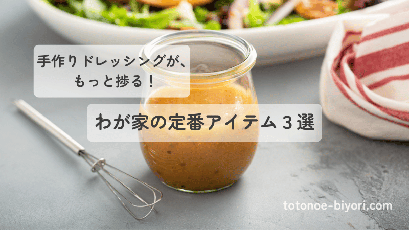 小さな泡立て器と手作りドレッシングが入ったガラス瓶。わが家の定番キッチンツールを紹介するイメージ。