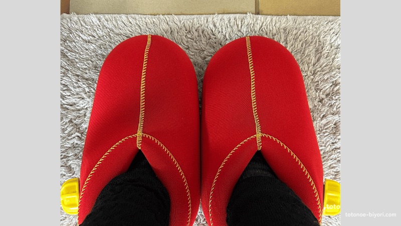 フローリングの冷気を防ぐため、ラグの下にダンボールを敷いて断熱対策をしている様子。