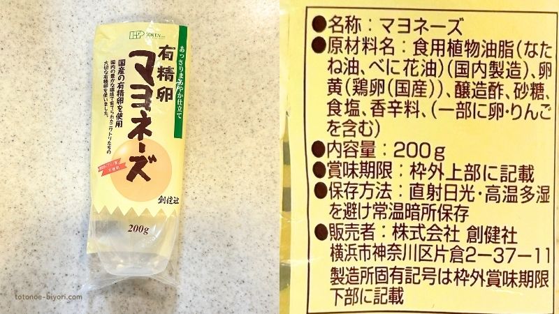 創健社の有精卵マヨネーズ(200g)のパッケージと原材料表示のラベル。原材料は食用植物油脂(なたね油、べに花油)・卵黄(国産鶏卵)・醸造酢・砂糖・食塩・香辛料で、「/」以降の添加物の表示はない